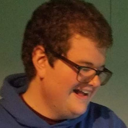 A picture of Jordan smiling looking down and to the right.